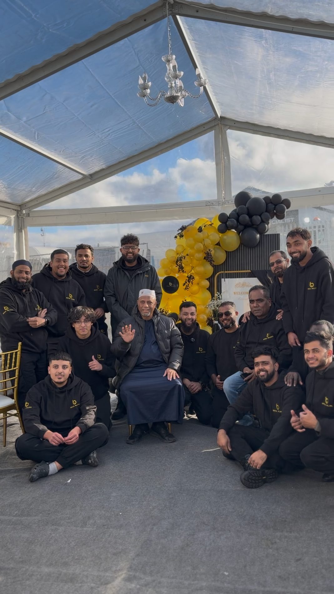 The Bengal Welding team, gathered in black company hoodies under a marquee decorated with gold and black balloons