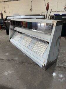 Wall-mounted extraction canopy angled on the workshop floor